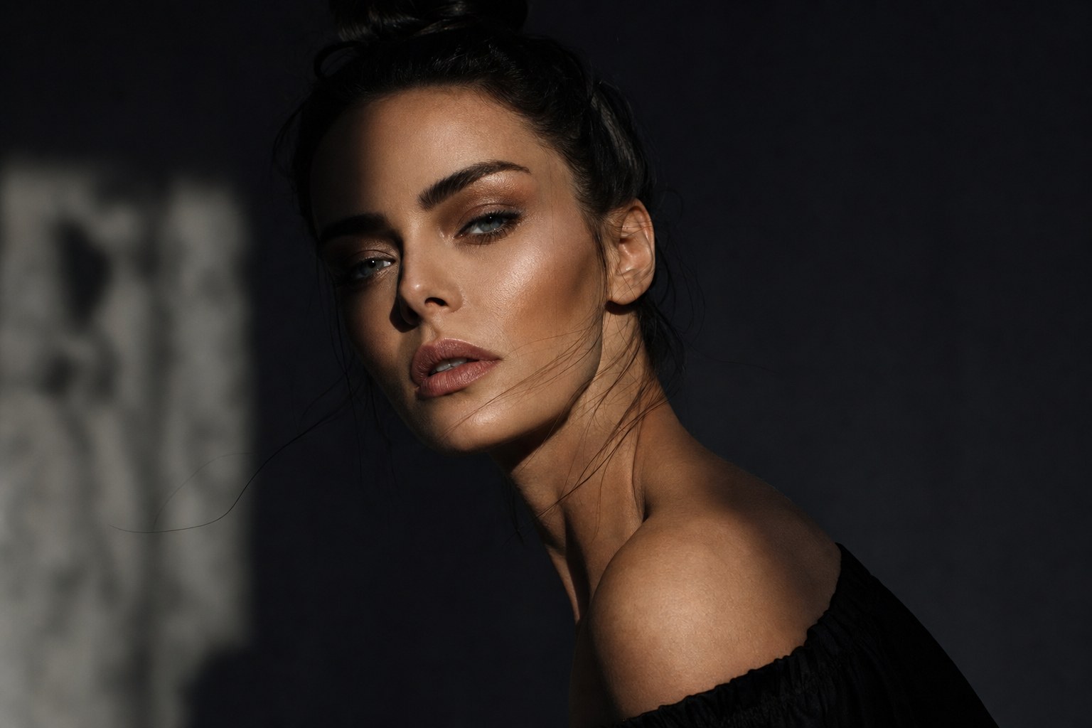 Cinematic studio portrait, dramatic key light on a moody backdrop
